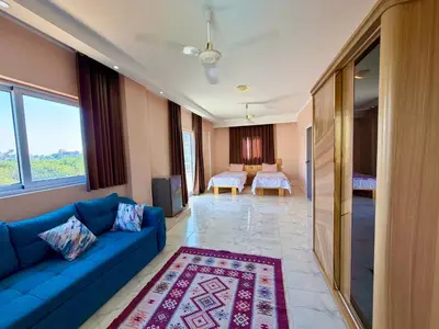 a living room with a blue couch and a bedroom at Sylvie guest house in Luxor