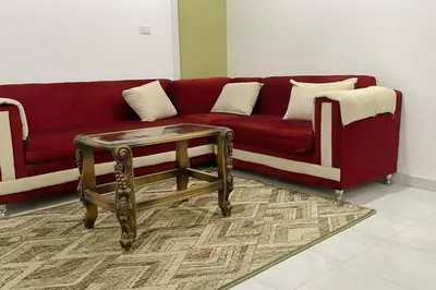 a living room with a red couch and a coffee table at Mado luxury villa with private pool in Luxor