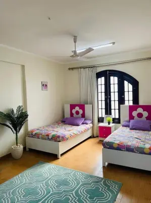a bedroom with two beds and a potted plant at Mado luxury villa with private pool in Luxor