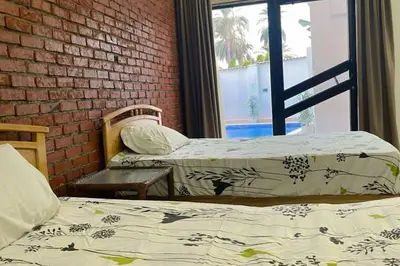 two beds in a room with a brick wall at El Hady villa with swimming pool in Luxor