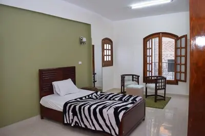 a bedroom with a bed and a table and chairs at El Hady villa with swimming pool in Luxor