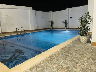 a large swimming pool with blue water in a building at El Hady luxury apartment with swimming pool in Luxor
