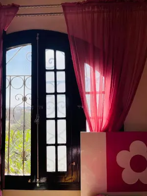 a room with a window with red curtains at El Hady luxury apartment with swimming pool in Luxor
