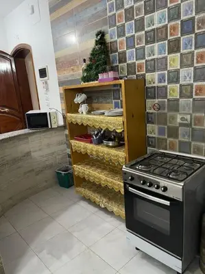 a kitchen with a stove and a shelf with food at El Hady luxury apartment with swimming pool in Luxor