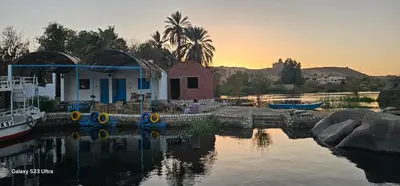 a house in the water with a boat in it at Hannag Island Guest house in Aswan