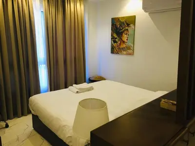 a hotel room with a white bed and a table at Fanadir Bay in Hurghada