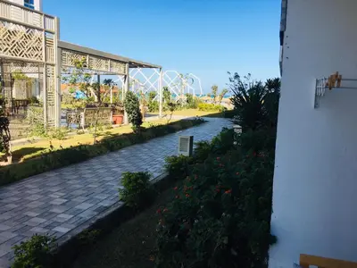 a walkway leading to a park with a roller coaster at Fanadir Bay in Hurghada