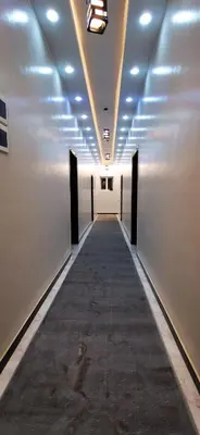 a hallway with white walls and a long hallway with doors at Luxor Sapphire in Luxor