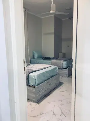 two beds in a room with marble floors at Diamond Guest House K in Aswan