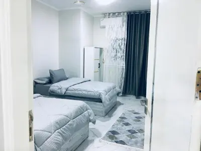 a bedroom with two beds and a mirror at Diamond Guest House K in Aswan