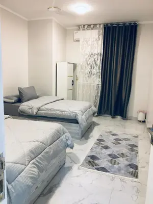 a bedroom with two beds and a rug on the floor at Diamond Guest House K in Aswan