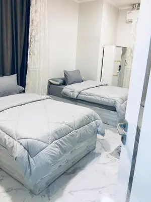 a bedroom with two beds and a mirror at Diamond Guest House K in Aswan
