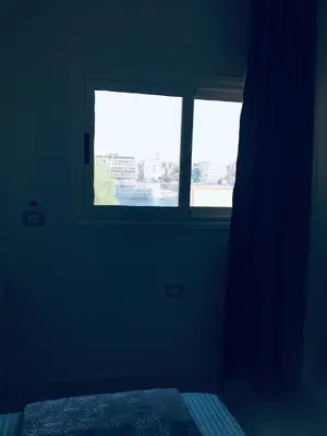 a dark room with a window and a bed at Diamond Guest House K in Aswan