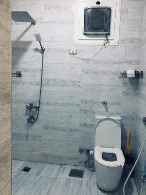 a bathroom with a toilet and a shower with a window at Diamond Guest House K in Aswan