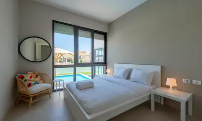 a bedroom with a bed and a mirror and a pool at Luxury Villas in Tawila El Gouna in Hurghada