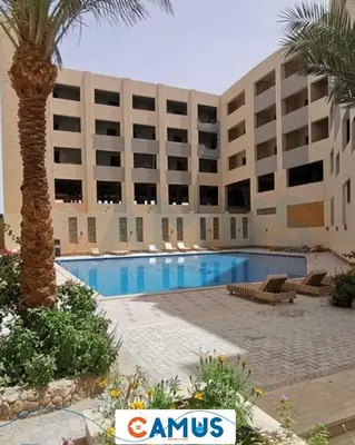 a hotel with a swimming pool in front of a building at CAMUS 110 A, Princess Resort in Hurghada