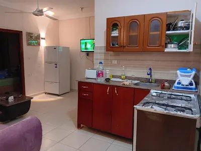 a kitchen with red cabinets and a white refrigerator at Dream sea Apartment in Hurghada