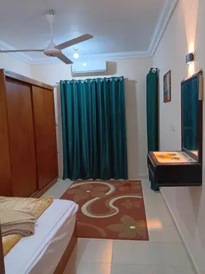 a bedroom with a bed and a green curtain at Dream sea Apartment in Hurghada