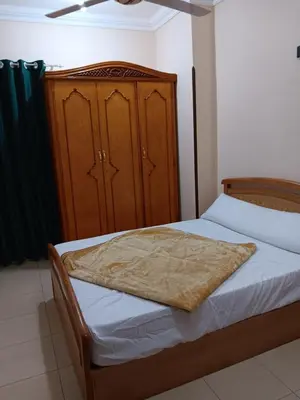 a bedroom with a bed and a wooden cabinet at Dream sea Apartment in Hurghada