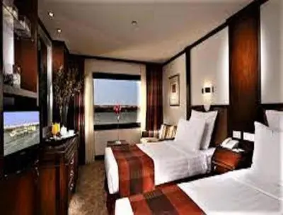 a large bedroom with two beds and a large window at Nile Cruise FB 3 Nights Aswan Luxor in Aswan