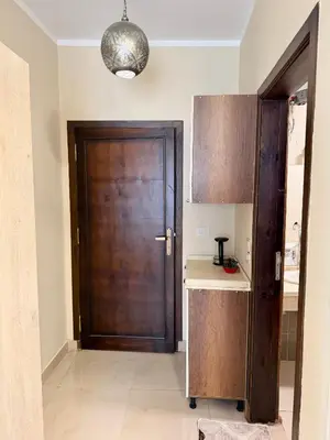 a kitchen with a wooden door and a counter at Sheherazade Hotel Nile Villa in Luxor
