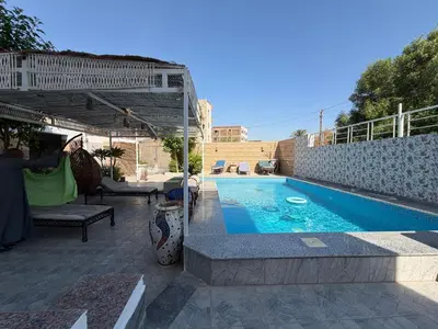a swimming pool in a yard next to a building at Sylvie guest house I in Luxor