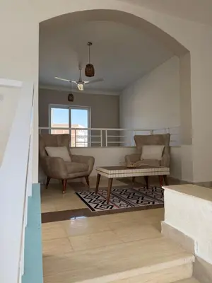 a living room with two chairs and a coffee table at Sylvie guest house I in Luxor