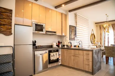 a kitchen with a refrigerator and a stove top oven at 4 Bedrooms, Luxury Villa Makadi Heights in Hurghada