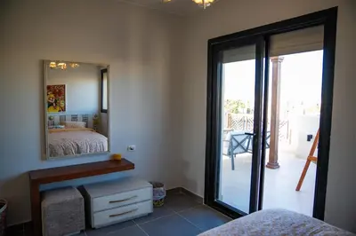 a bedroom with a mirror and a bed and a balcony at 4 Bedrooms, Luxury Villa Makadi Heights in Hurghada