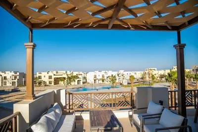 a patio with chairs and a table on a balcony at 4 Bedrooms, Luxury Villa Makadi Heights in Hurghada
