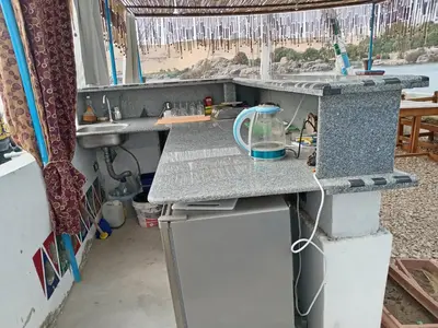 a kitchen with a counter and a sink and a refrigerator at Nile Bride in Aswan