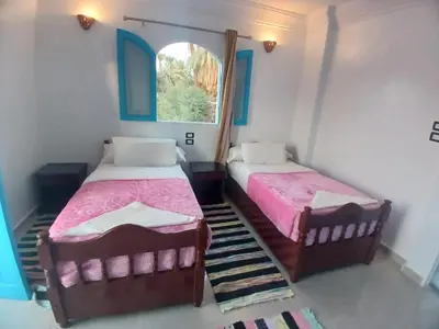 two beds in a room with a window at Nile Bride in Aswan