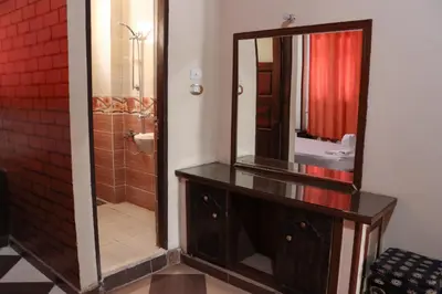 a bathroom with a large mirror on a wooden dresser at Kulaih nubian guest house in Aswan