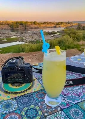 a drink sitting on a table next to a camera at Kulaih nubian guest house in Aswan