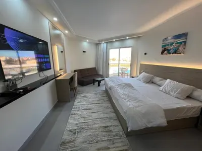 a bedroom with a large bed and a flat screen tv at scandic resort sea view in Hurghada