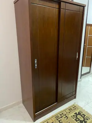 a large wooden cabinet in a room with a rug at Tiba A F B View in Hurghada