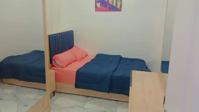 a small bedroom with a bed and a mirror at اهلا بيكم في بيتنا in Jazīrat al ‘Awwāmīyah