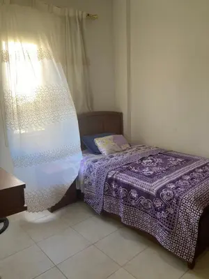 a small bed in a room with a window at M-2bedroom flat with garden in Hurghada