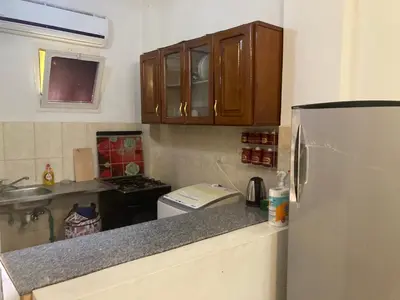 a kitchen with a refrigerator and a counter top at M-2bedroom flat with garden in Hurghada