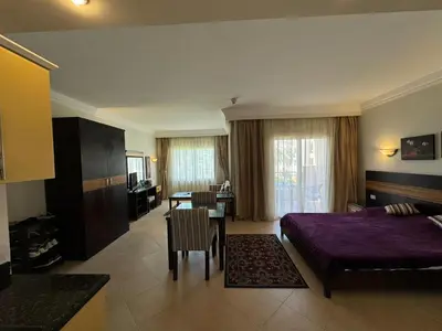 a hotel room with a bed and a dining room at Cozy Sunny Studio with Pool View - Sahl Hasheesh in Hurghada