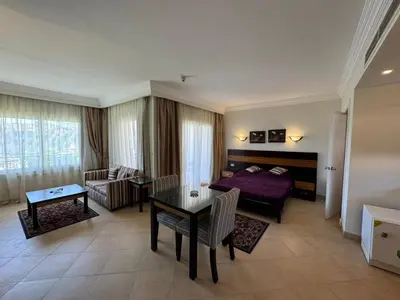 a living room with a bed and a table at Cozy Sunny Studio with Pool View - Sahl Hasheesh in Hurghada
