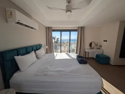 a bedroom with a large bed with a large window at Supreme Beachfront 3BR Villa Soma bay with Garden in Hurghada