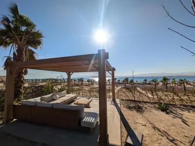 a couch under a gazebo on the beach at Supreme Beachfront 3BR Villa Soma bay with Garden in Hurghada