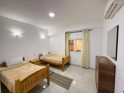 a bedroom with two beds and a tv in it at Spacious 3BR Apartment - Al Dora Resort, Hurghada in Hurghada