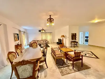 a living room with a table and chairs at Spacious 3BR Apartment - Al Dora Resort, Hurghada in Hurghada