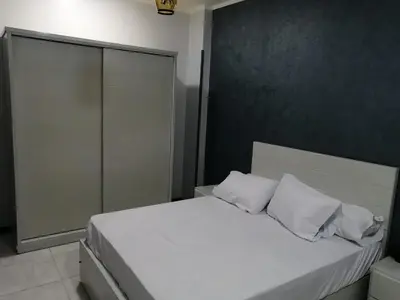 a bedroom with a bed with white sheets and pillows at Lutos Flower Apartment in Luxor