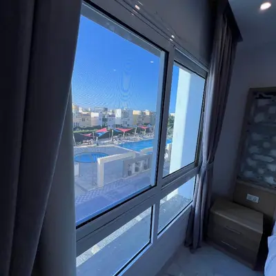 a window in a hotel room with a view of a pool at Modern Retreat with Red Sea View - Fanadir bay in Hurghada