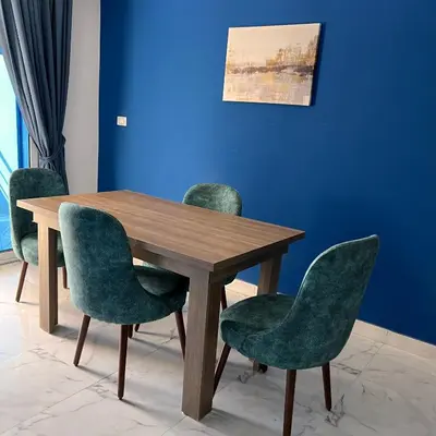 a wooden table with green chairs and a blue wall at Modern Retreat with Red Sea View - Fanadir bay in Hurghada