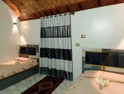 a bedroom with two beds and a curtain in it at Rammy Guest House in Aswan