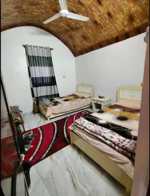 two beds in a room with a ceiling at Rammy Guest House in Aswan